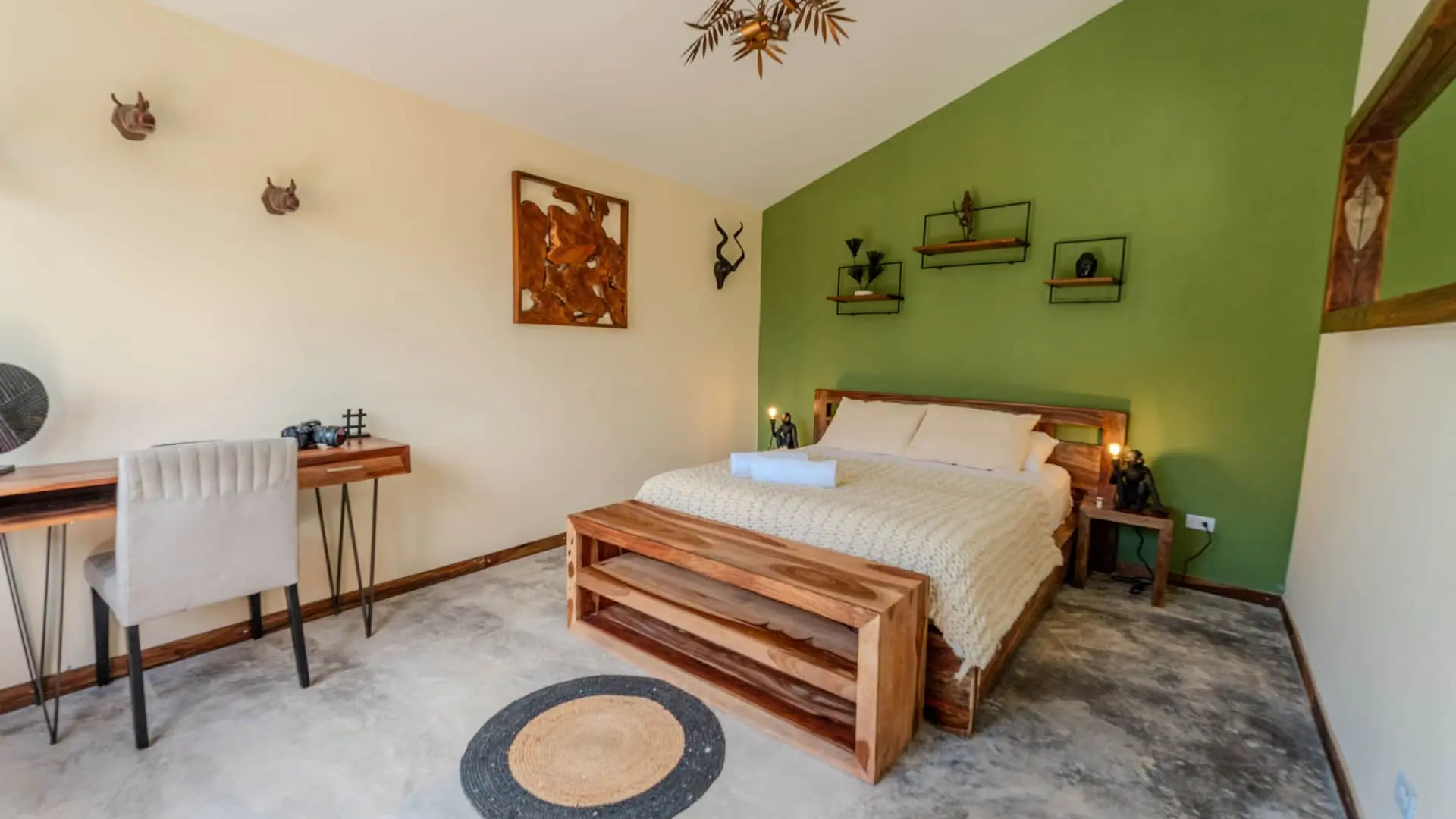 Aurora Coronado cabin bedroom with green accent wall and handcrafted wood furniture